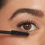 خانم در حال استفاده از ریمل IT Cosmetics Superhero برای حجم دادن و بلند کردن مژه‌ها
